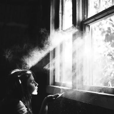 A person sneezing near floating dust, illustrating dust-triggered sneezing.