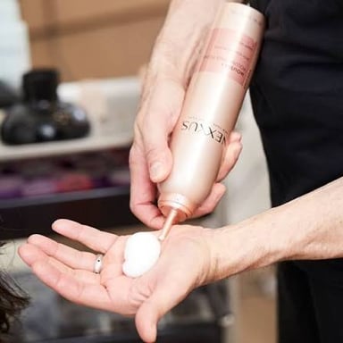 Styling mousse foam being applied to hair.
