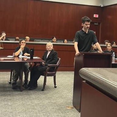A person standing before a judge in a courtroom during a trial.