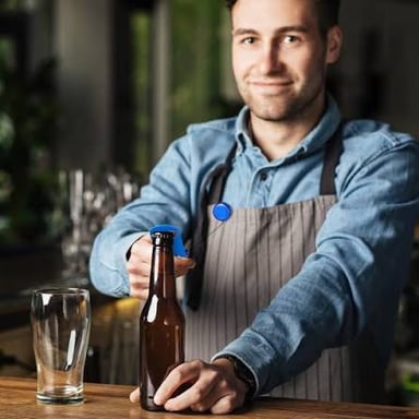 A bartender removing a bottle cap with an opener
