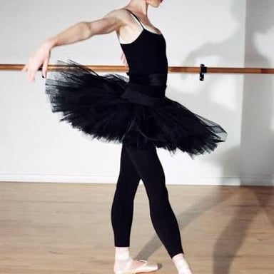 A ballet dancer in a tutu performing a gliding step.