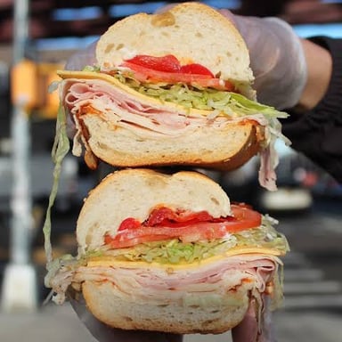A deli counter displaying sandwiches and prepared foods