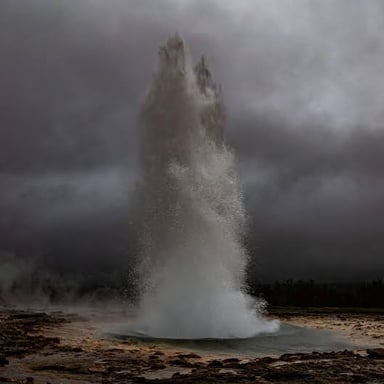 A geyser forcefully sends a plume of water into the air.