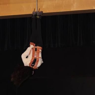 An escape artist attempting to free themselves from a straitjacket.