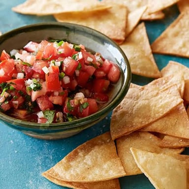 Chips beside a shared bowl of dip.