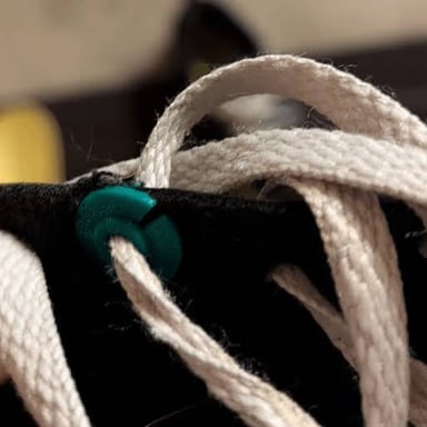 Shoelaces threaded through a shoe’s eyelets and tied.