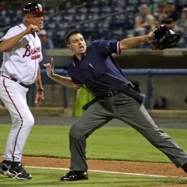 An umpire signaling that a player has been ejected from a baseball game
