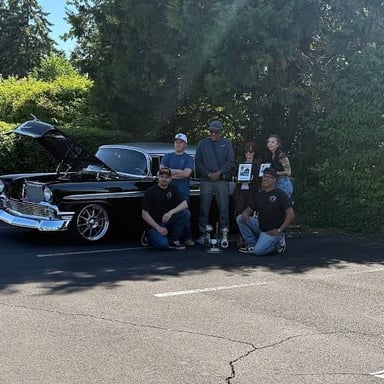 Automobile enthusiasts working on a car.