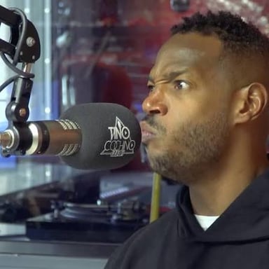 A radio host speaking into a microphone during a broadcast.