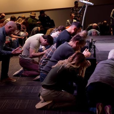 People gathered in prayer inside a church.