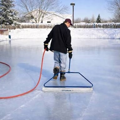 A Zamboni driving across an ice rink.