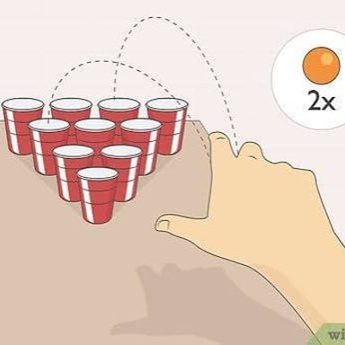 A ping-pong ball traveling in a curved arc toward cups on a table.