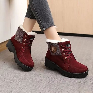 Snow reaching approximately ankle height around a person’s boots.