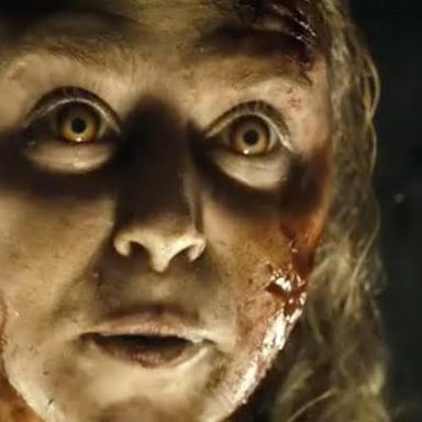 A startled person reacts to a sudden scare in a horror scene.