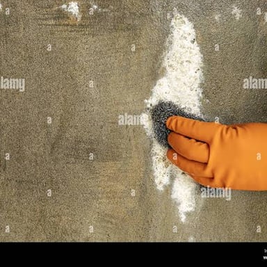 A person vigorously cleaning a surface with a brush