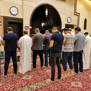 An imam leading worshippers in prayer inside a mosque