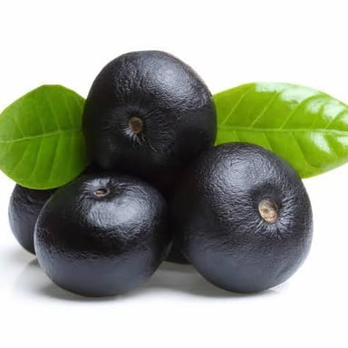 Small dark-purple açaí fruits growing in clusters on a palm.