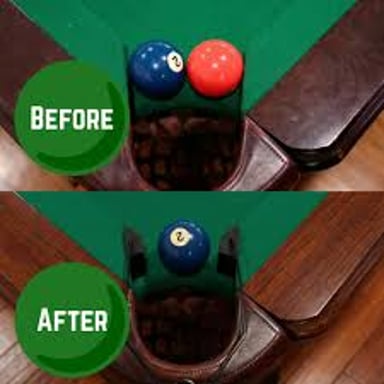 A billiards table with colored balls and a ball dropping into a pocket.