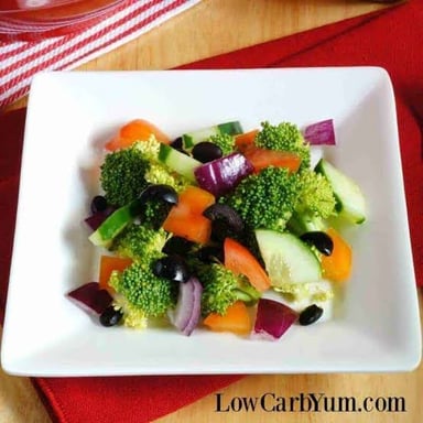 A broccoli head and a cucumber, two examples of vegetables.