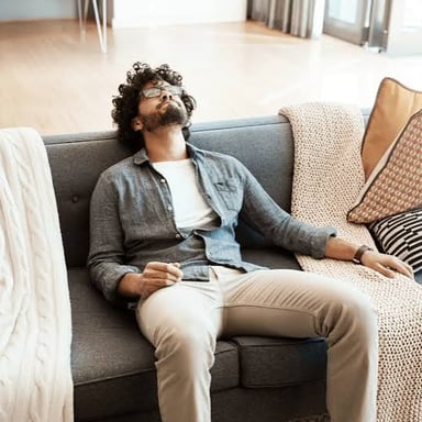 A person lounging on a couch and doing nothing.