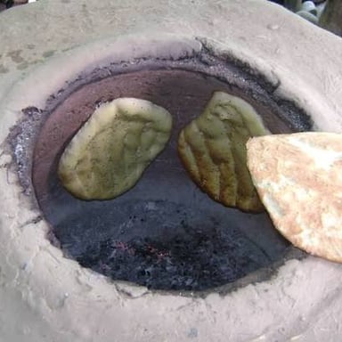 Pieces of naan flatbread, lightly browned from baking.