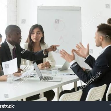Coworkers disagree during a meeting around a table.