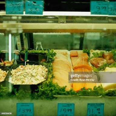 A supermarket deli counter where customers wait for numbered orders.