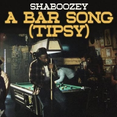 Shaboozey performing onstage with a microphone.