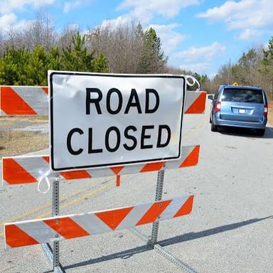 A road blocked by barricades representing a roadblock.