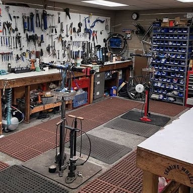 Bicycles and repair tools are visible inside a bicycle shop.