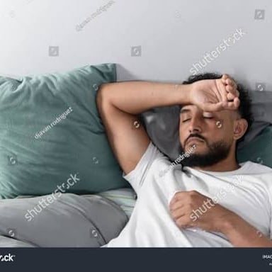 A person appearing unwell and holding their forehead