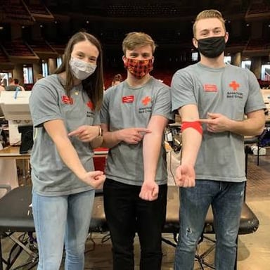 Red Cross volunteers assisting donors at a blood donation drive.