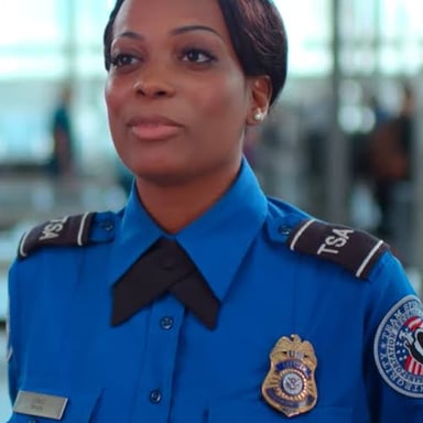 An airport security officer wearing a uniform marked with TSA identification