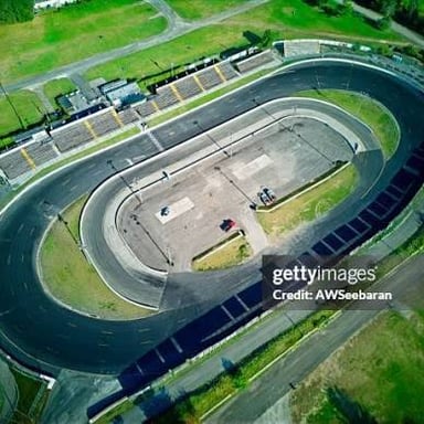 An oval motor-racing track with stock cars competing.
