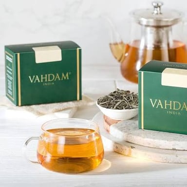 Cups and loose leaves representing oolong and Darjeeling tea.