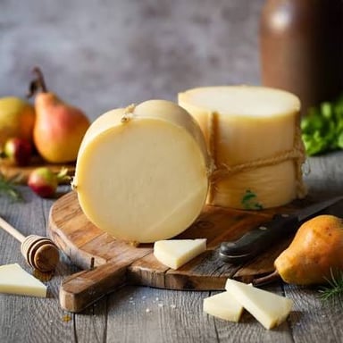 A wheel of provolone cheese with several slices cut from it.