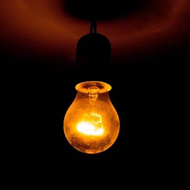 A bright lamp casting light in a dark room.