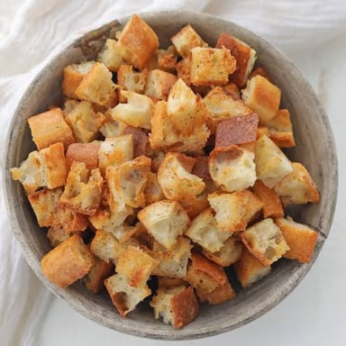 Golden, crisp bread cubes used as croutons in a salad or soup.
