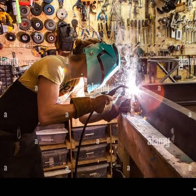 A metalworker joining steel pieces with a welding torch.