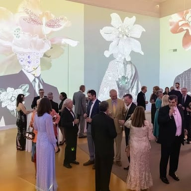 Guests dressed for a formal evening event in an art gallery.
