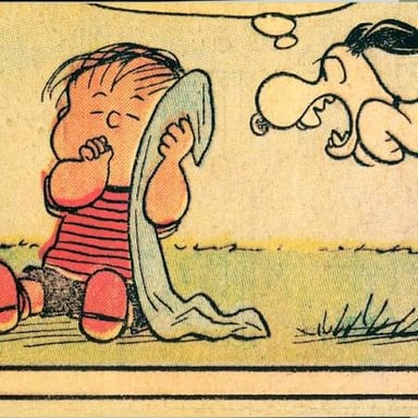 The Peanuts character Linus holding his familiar security blanket.