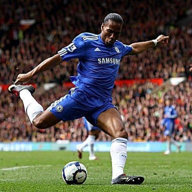 A soccer player kicking the ball toward a goal