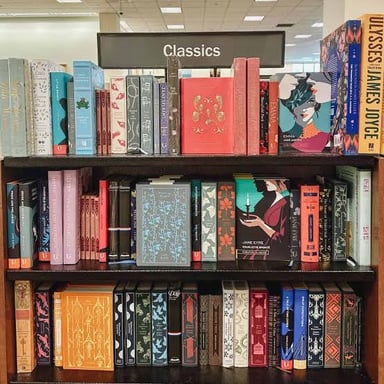 A row of well-known classic novels on a bookshelf.