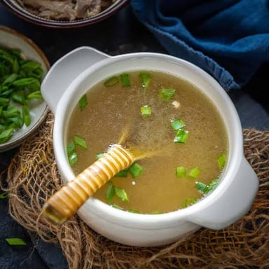 A pot containing clear broth used as a soup base