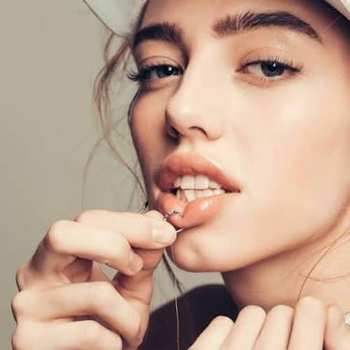 A close view of a person wearing a ring through a lip piercing.