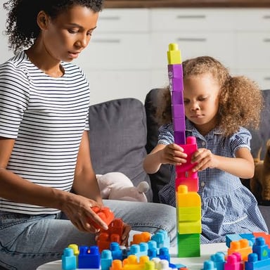 A caregiver spending time with young children in a home.