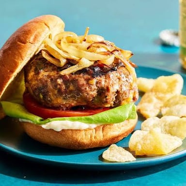 A cooked hamburger patty served in a bun.