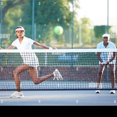 A tennis player serves the ball over the net.