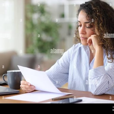 A person closely examining a document at a desk.