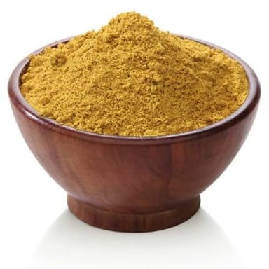 Small brown cumin seeds in a bowl beside curry spices.